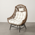 Brown Rattan High-Back Egg Chair with Tufted White Cushion and Metal Base